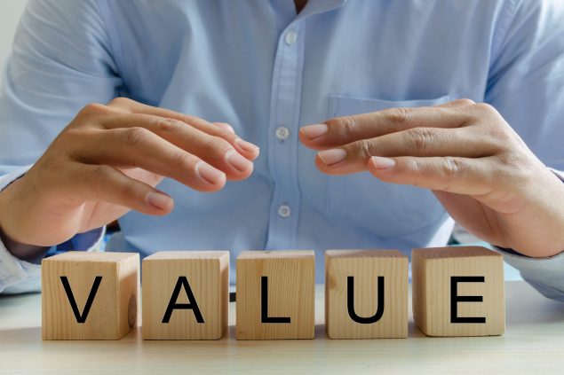 Hand businessman wooden cube value text. Business concept.